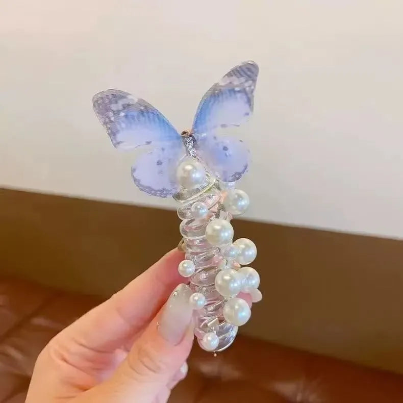 Colourful butterfly and pearl elastic hair band for children on a white background.