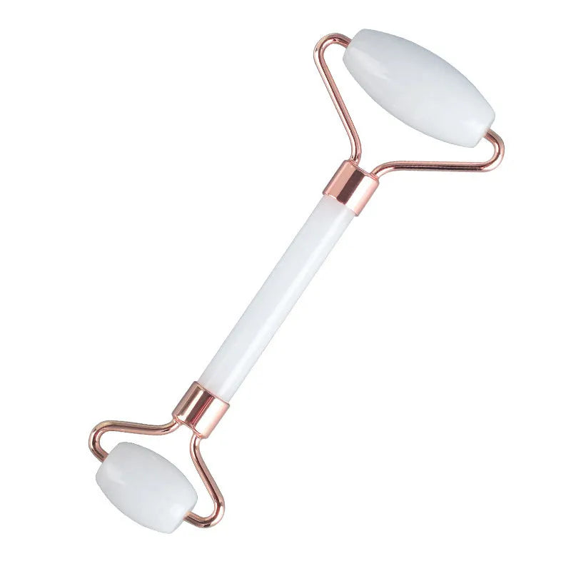 White jade facial roller with double-headed claw design and matching scraping board on dark surface