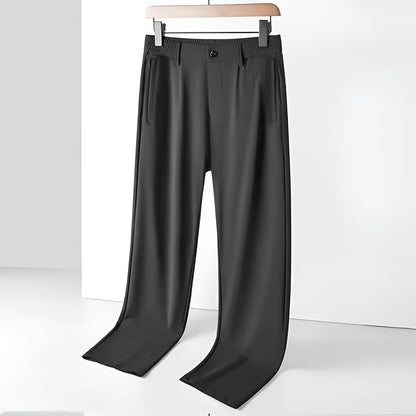 Man wearing black Ice Silk loose-fit casual trousers with an elastic waistband.