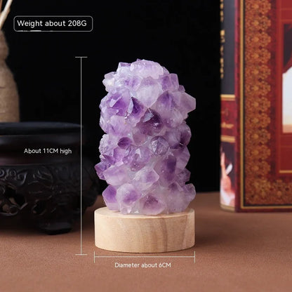 Mini USB night light glowing inside a natural amethyst crystal vug geode on a dark surface.