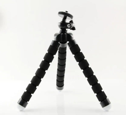 Black flexible octopus tripod with legs wrapped around a pole, holding a smartphone with a clip mount.