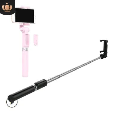 Aluminium tripod selfie stick with extended phone clip and Bluetooth remote on a table
