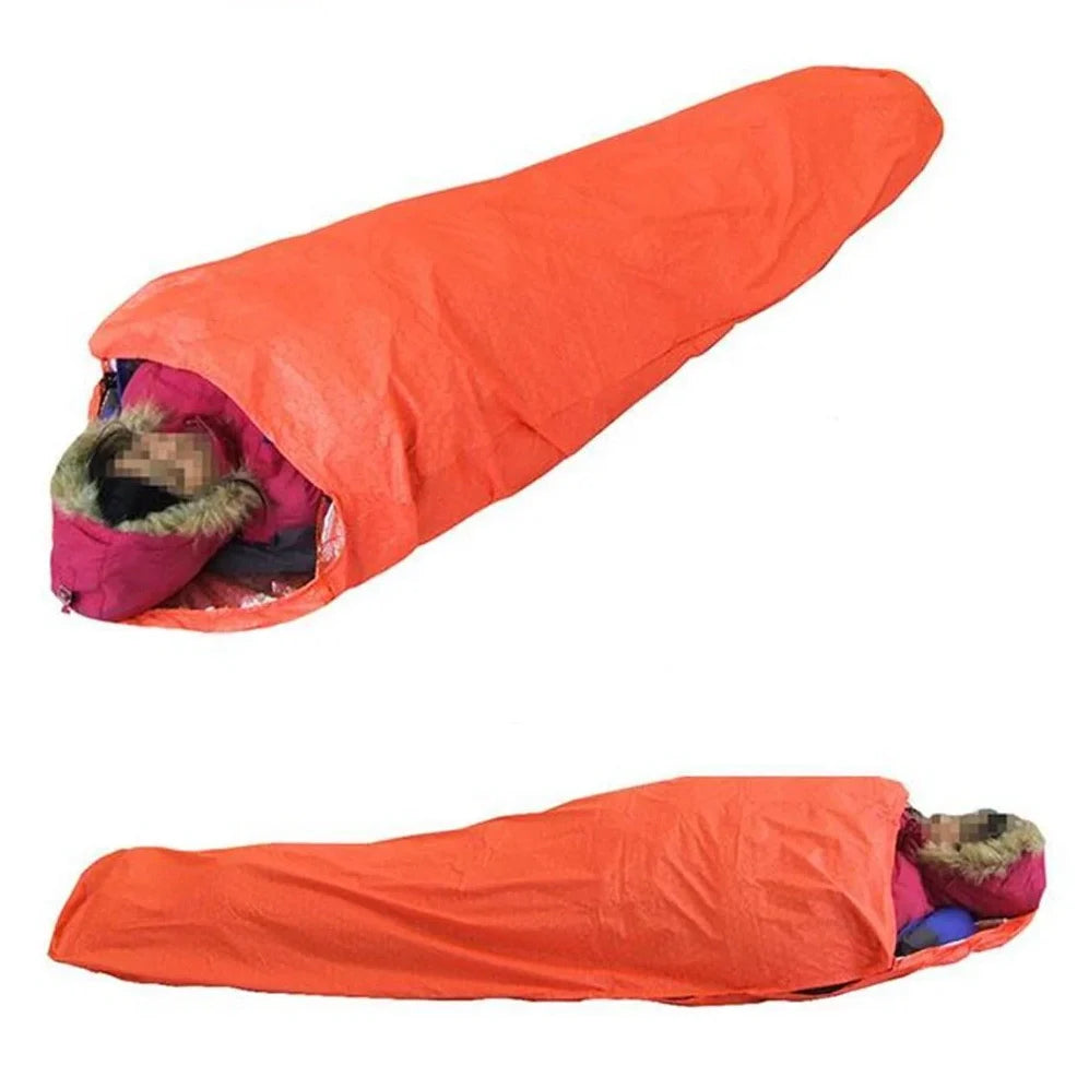 Orange outdoor thermal sleeping bag with silver coated nylon showing envelope design and storage bag