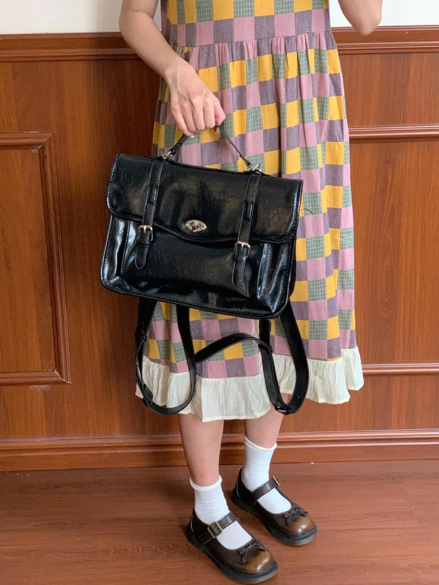 Black college style messenger bag made of oil wax PU leather, shown with a single shoulder strap.