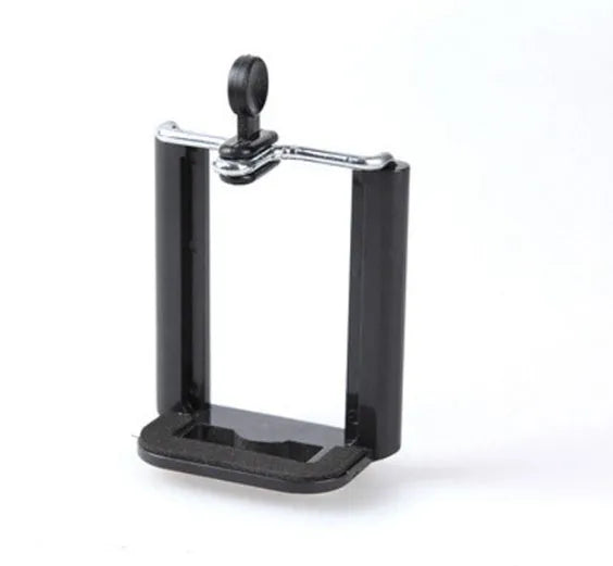 Black mini camera tripod with extended legs and a separate U-shaped universal phone clip on a table.