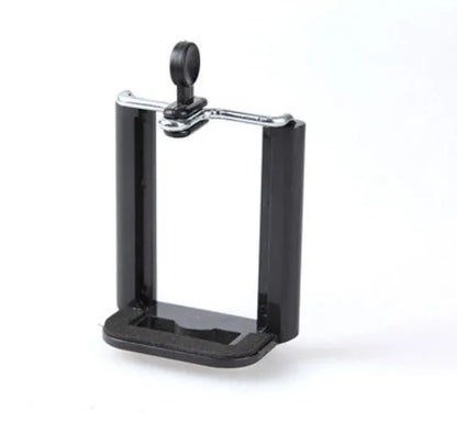 Black mini camera tripod with extended legs and a separate U-shaped universal phone clip on a table.
