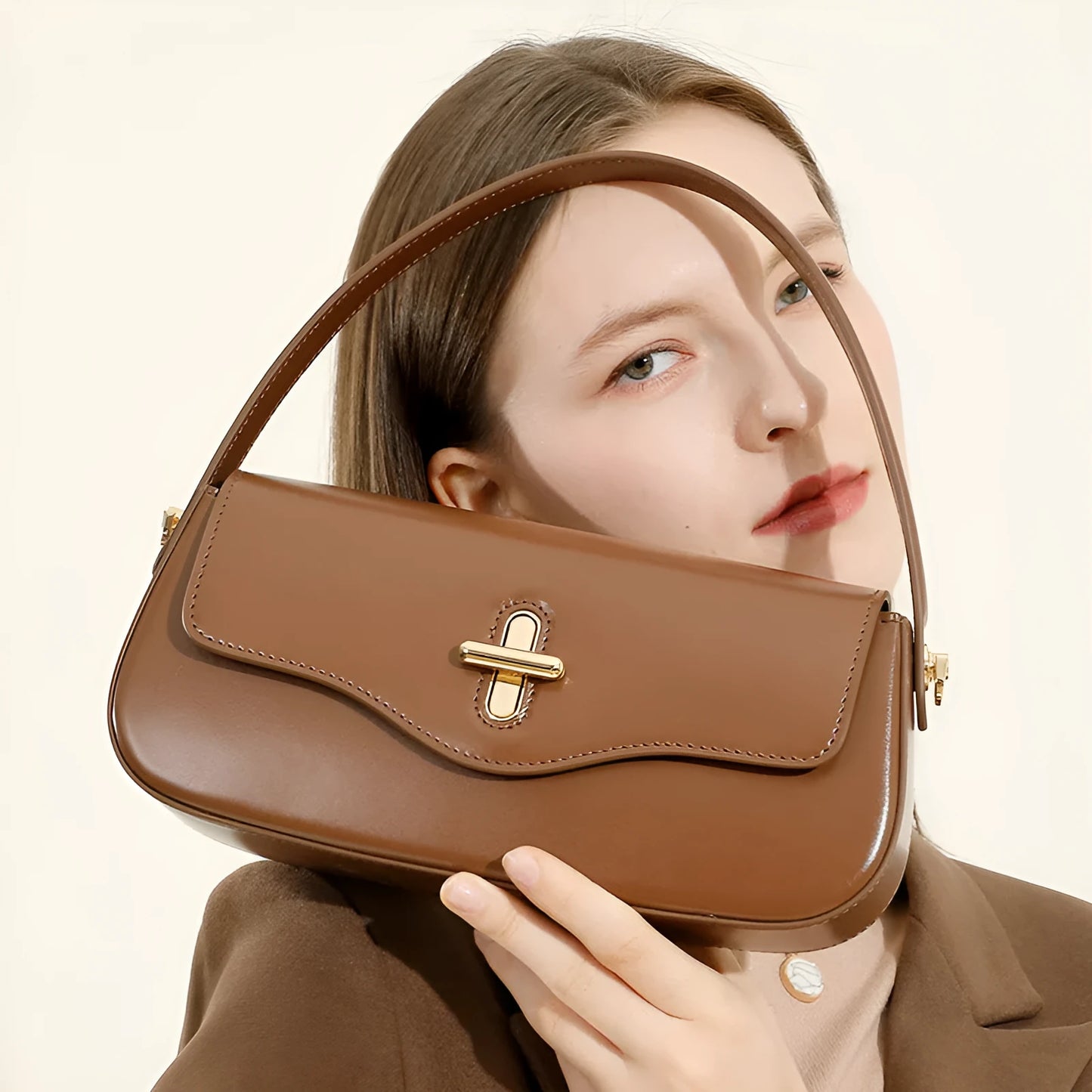 Genuine leather baguette handbag in horizontal square shape with clamshell opening and internal zip compartments