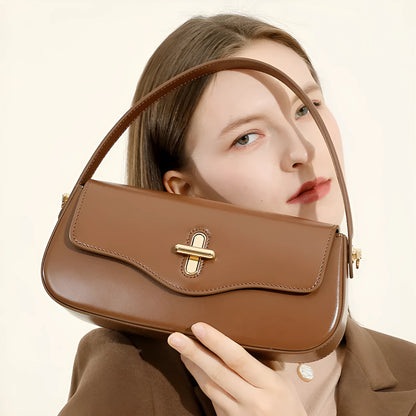 Genuine leather baguette handbag in horizontal square shape with clamshell opening and internal zip compartments