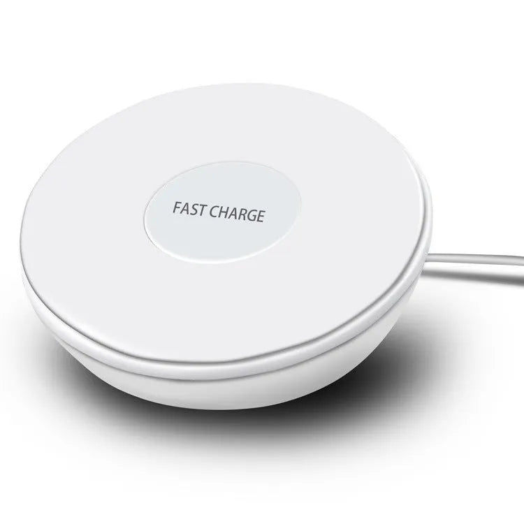 White wireless charging pad with digital clock display and three control buttons on a bedside table.