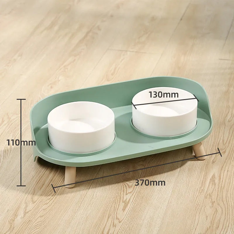Green tilted pet feeder with adjustable stainless steel frame and two food bowls for cats and dogs
