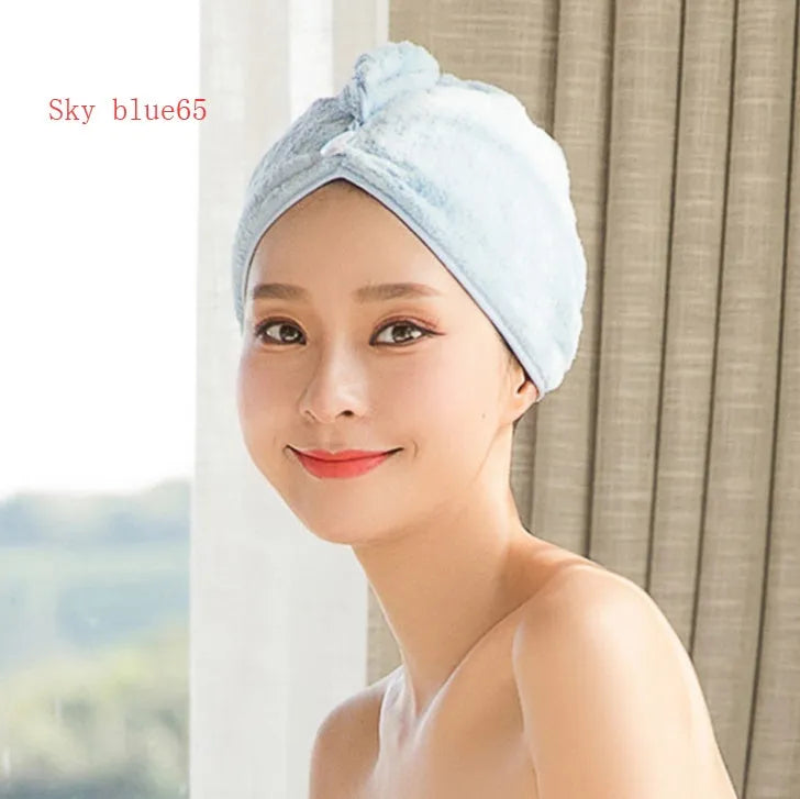 A woman wearing a sky blue microfiber hair dryer cap, with wet hair tucked inside, showing the towel's wrap-around design.