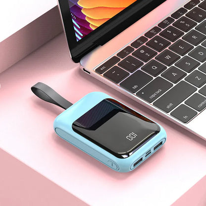 White portable power bank with 20000mAh capacity and multiple USB output ports on a table.