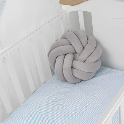 Knotted lumbar pillow with memory foam fill showing adjustable height feature and polyester cover