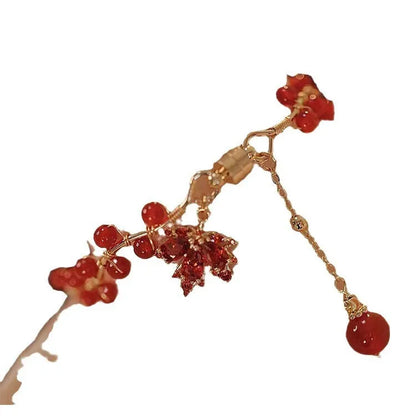 Red ginkgo leaf charm magnetic bracelet for girls on a wrist, showing maple leaf design details.
