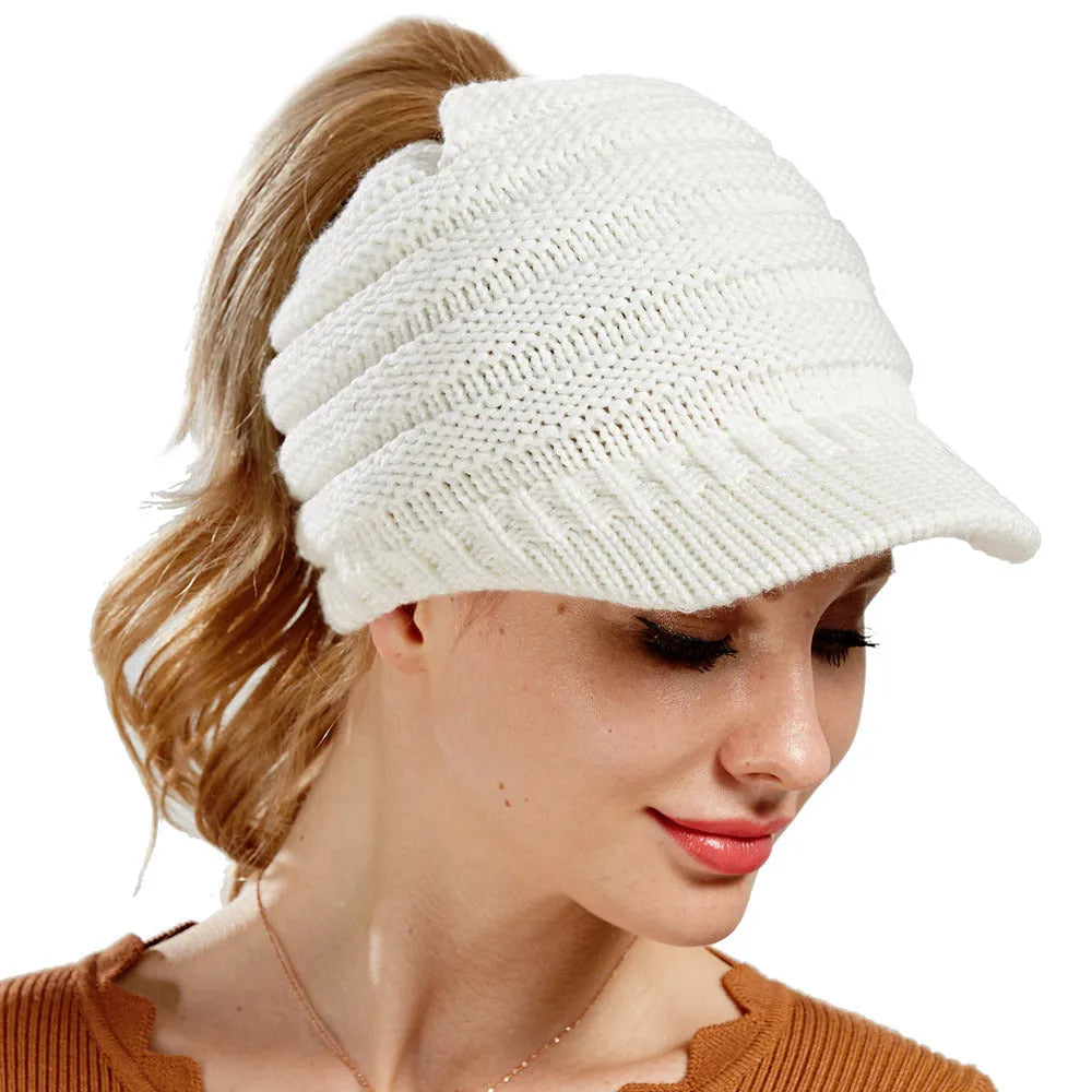 Women's acrylic knitted ponytail beanie in a solid colour, shown on a model with a ponytail.