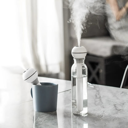 Pink and white columnar magic wand ultrasonic humidifier with USB cable and mechanical knob.
