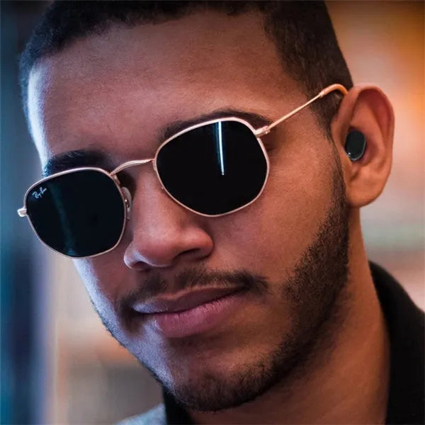 Black and white M1 wireless Bluetooth earbuds with a charging case on a neutral background.