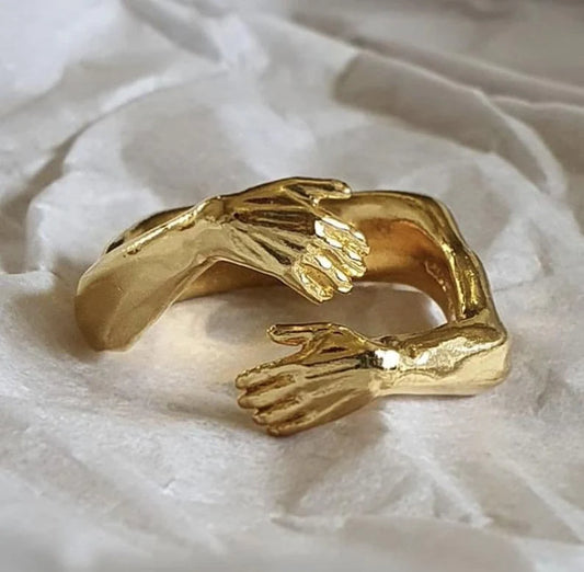 Adjustable Love Hands Embracing Ring in gold and silver, symbolising unity and affection.