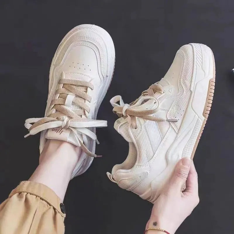 Pink and milky white low-top height-increasing sneakers with a rubber sole.