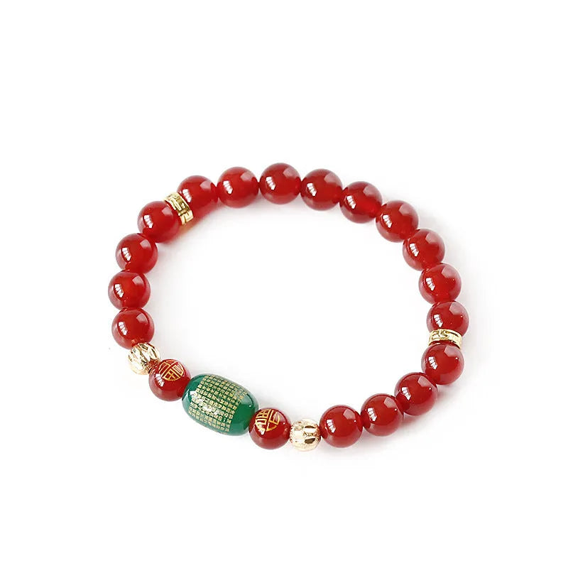 A red agate beaded bracelet with a Guanyin pendant on a white background.