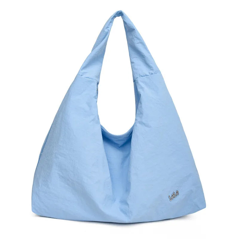 A soft nylon underarm bag with a heart-shaped design in blue, shown worn crossbody.