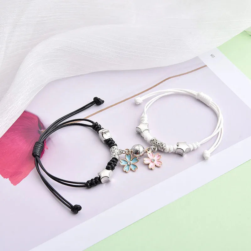 A pair of magnet couple bracelets with a suction clasp, showing various design options like clovers, crowns, and hearts.