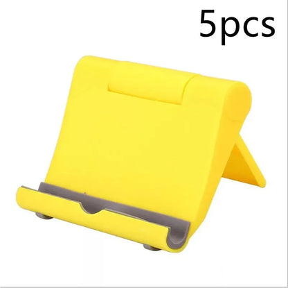 Black PE folding mobile phone stand holding a smartphone at an angle on a desktop.