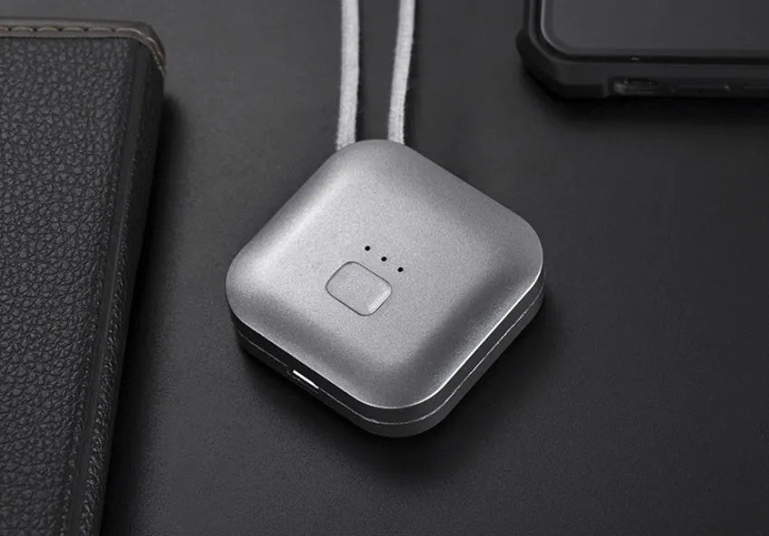 A person wearing a small, blue USB-rechargeable air purifier on a necklace, showing its compact size.