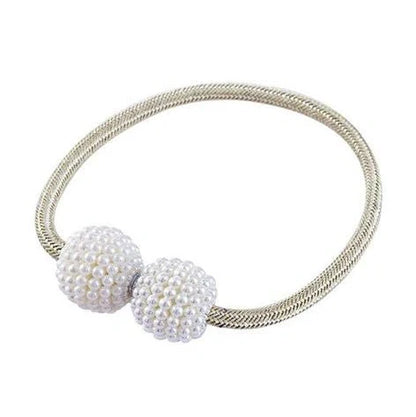 Magnetic curtain tiebacks with white pearl beads and fabric loops holding gathered curtain