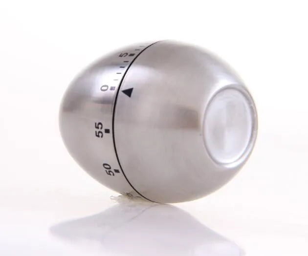 Stainless steel egg-shaped mechanical kitchen timer on a countertop.