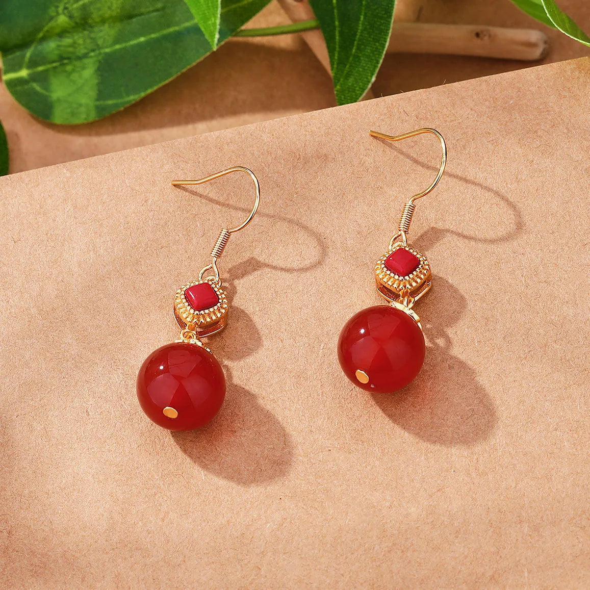 Geometric silver-toned earrings with round red agate beads and small inlaid jasper stone accents.