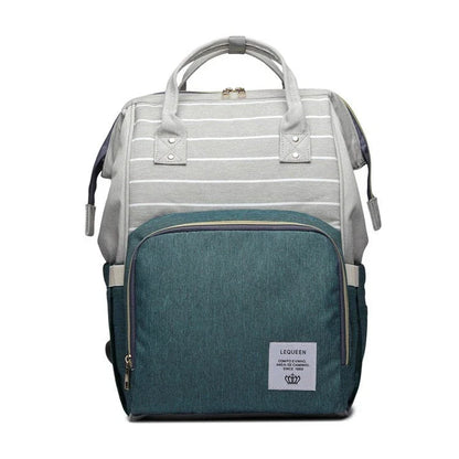 Stylish maternity diaper bag in various colors, featuring a paper bag design, separate bottle compartment, and discreet breastfeeding button.