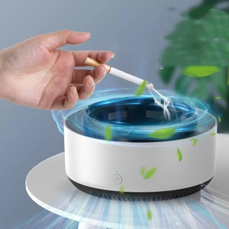 Grey intelligent electronic air purifier ashtray with fan, shown on a desk next to a cigarette.