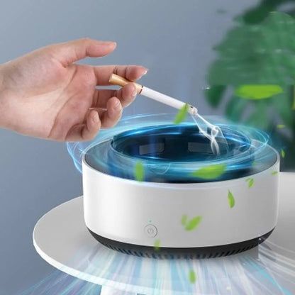 Grey intelligent electronic air purifier ashtray with fan, shown on a desk next to a cigarette.
