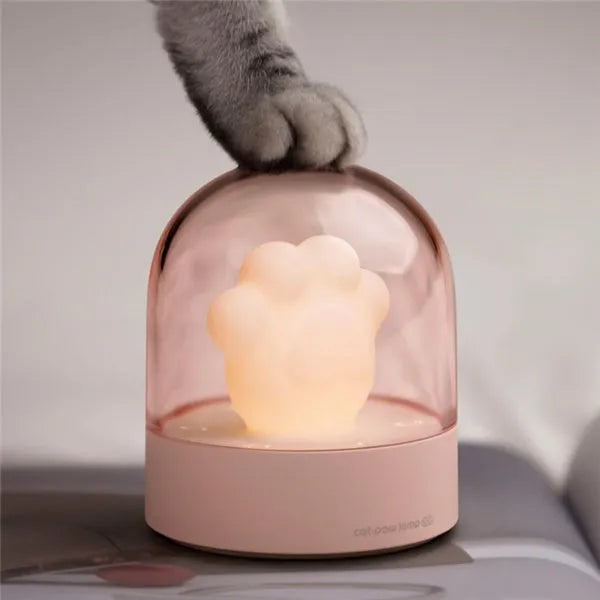 Grey cat paw-shaped night light with USB port, sitting on a surface, demonstrating its soft glow and cute design.