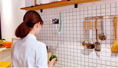 Black flexible gooseneck phone holder with suction cup base bent into an S-shape, holding a smartphone.