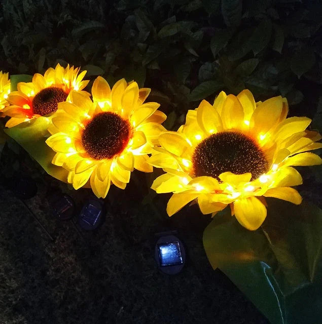Elegant solar-powered sunflower lamps illuminating a serene outdoor garden pathway