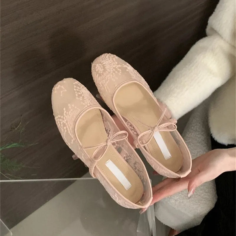 Pink Mary Jane evening shoes with flat lace, mesh upper, and a mid heel on a rubber sole.