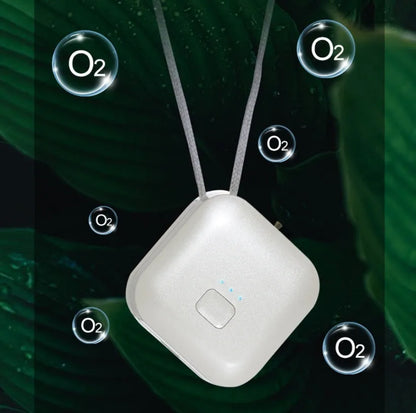 Compact pink USB air purifier necklace on a table with charging cable, showing dimensions 1.5 by 5.7 cm.