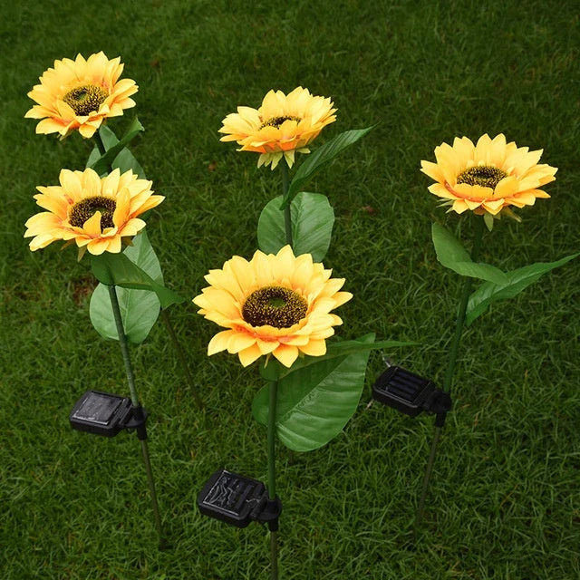 Elegant solar-powered sunflower lamps illuminating a serene outdoor garden pathway