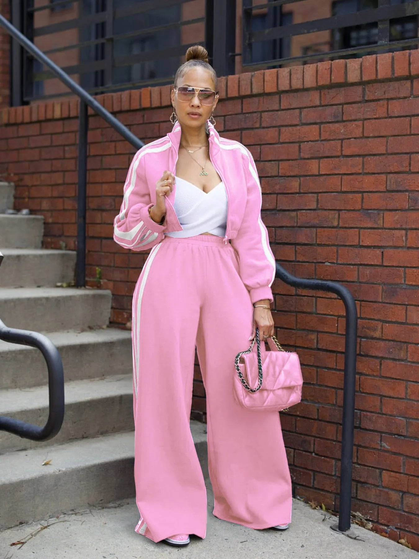 Woman wearing a grey striped zipper sweater and matching trousers from a casual two-piece set.