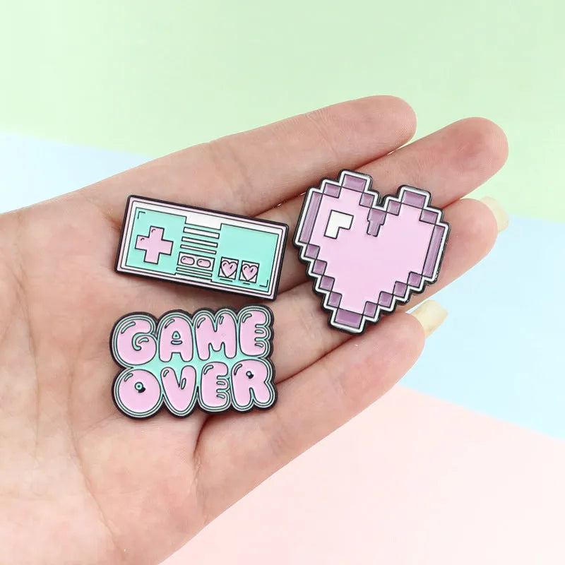 Stereo game console badge made of alloy metal for bag or jacket attachment.