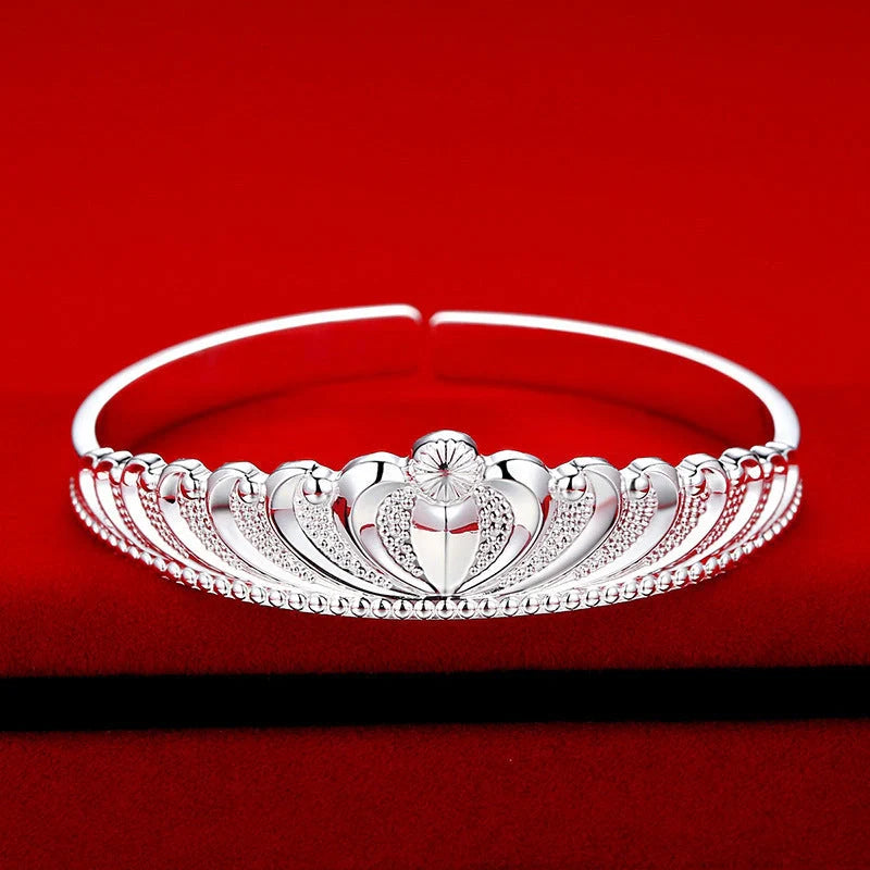 A close-up view of the elegant Crown Bracelet, showcasing its intricate crown-shaped design and shiny, rhodium-plated finish.