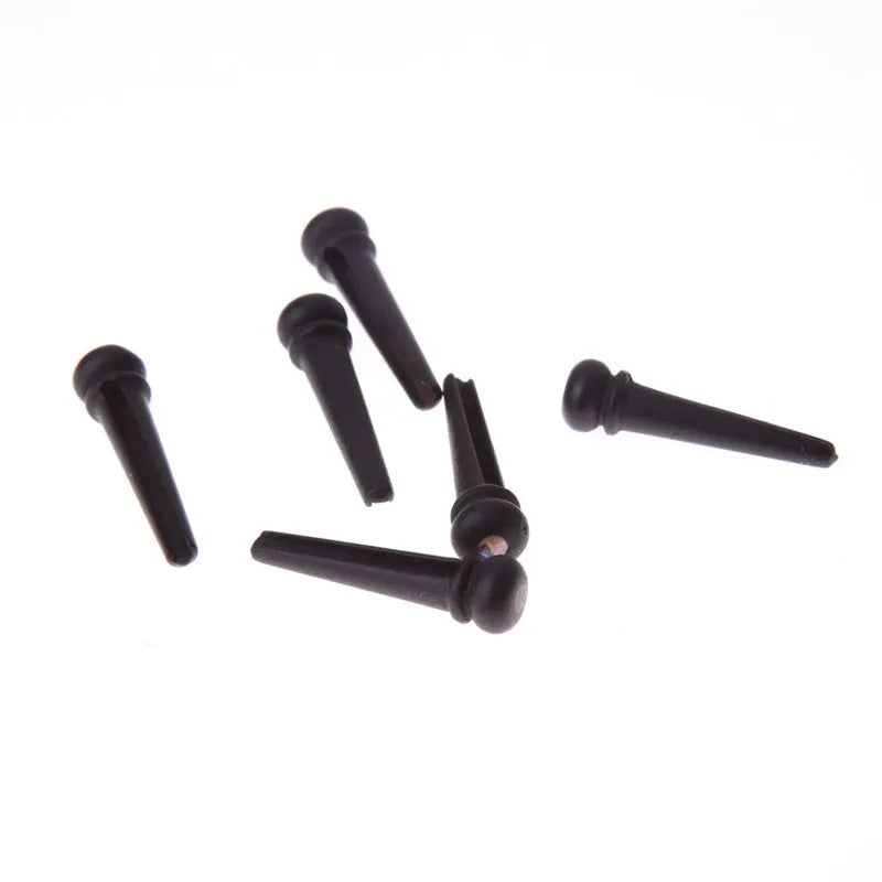 Six ebony folk guitar string nails with matte black finish and 5.3mm bayonet diameter