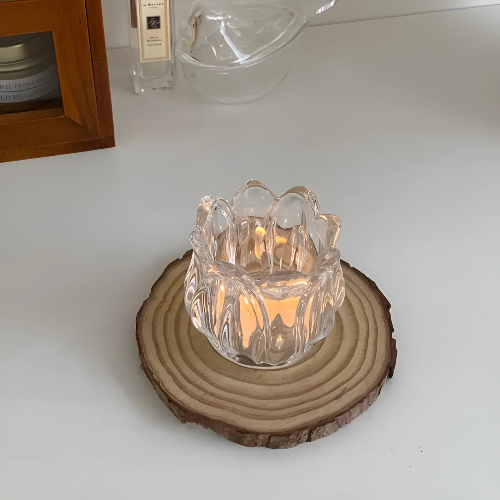 Transparent glass tulip candle holder with classic tumbler base on table