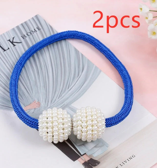 Magnetic curtain tiebacks with white pearl beads and fabric loops holding gathered curtain