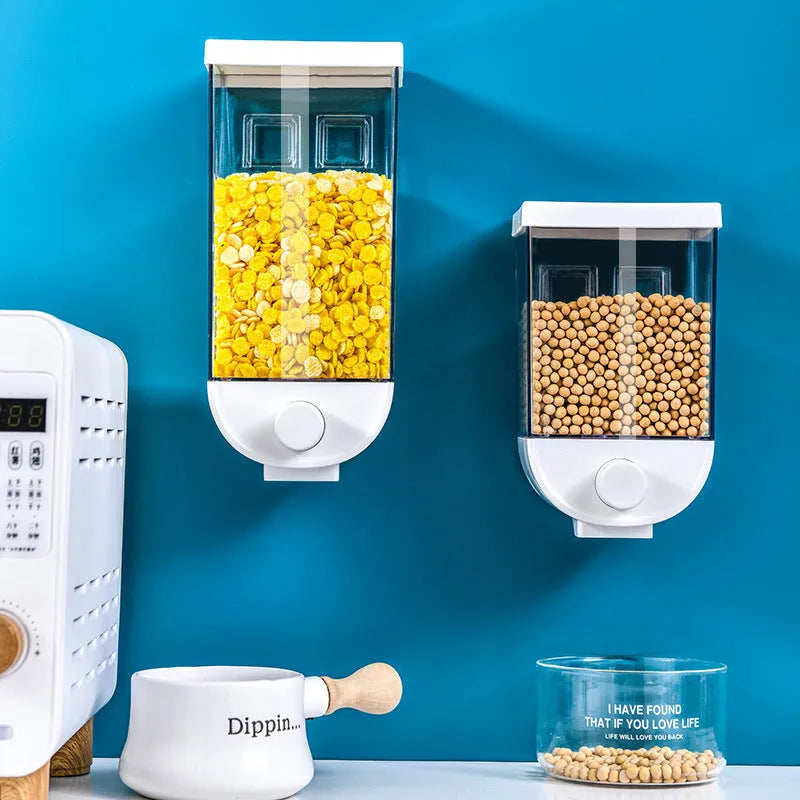 White wall-mountable kitchen food storage box with press lid dispenser, showing transparent body with cereal inside.