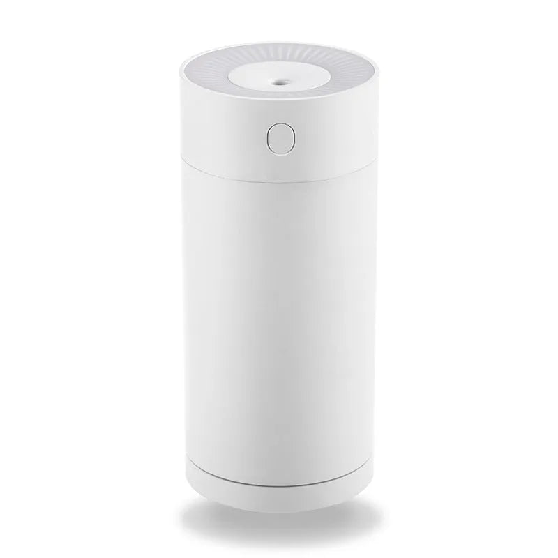 A compact white folding bracket USB humidifier on a desk next to a laptop, showing its size and USB cable.