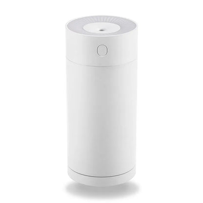 A compact white folding bracket USB humidifier on a desk next to a laptop, showing its size and USB cable.