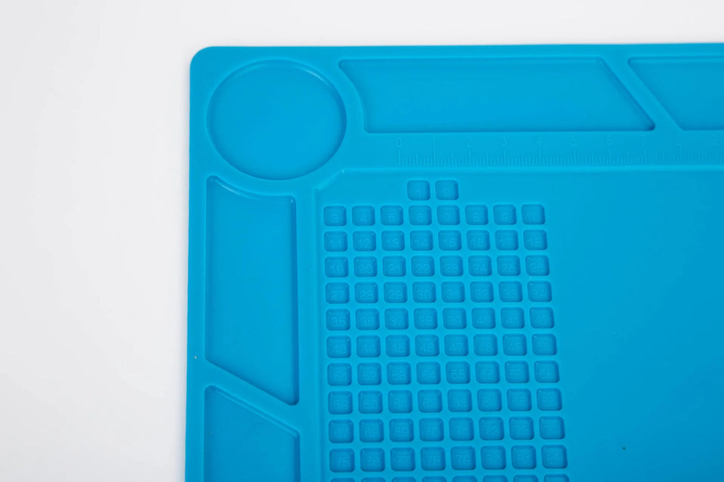 Blue silicone watch repair mat on workbench with watch tools